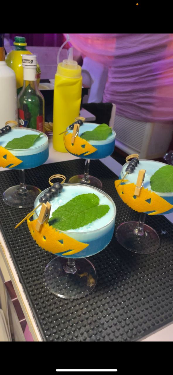 Highbridge Mix blue signature cocktail with berry garnish